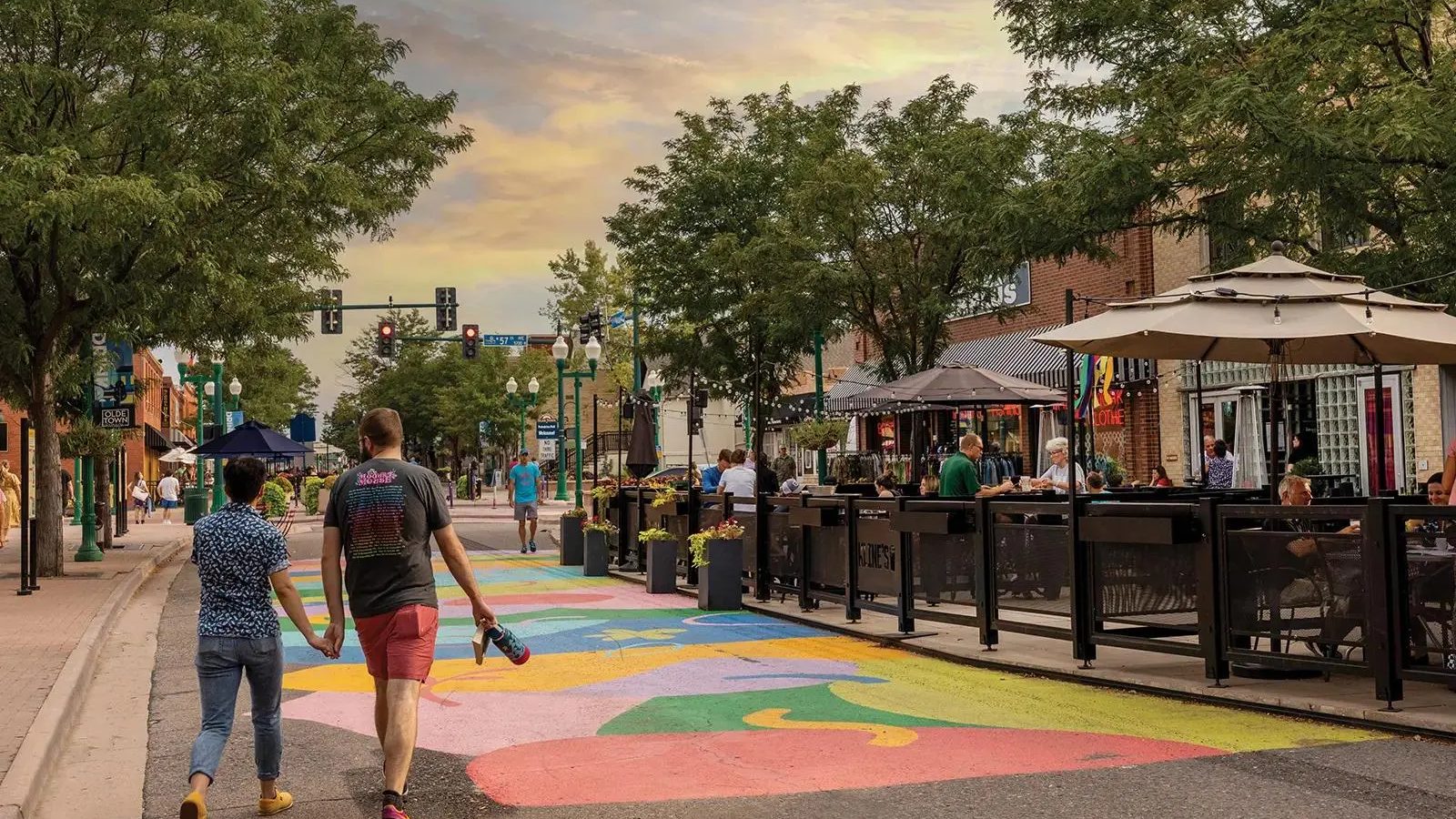 People walking through Olde Town Arvada past patios and shops