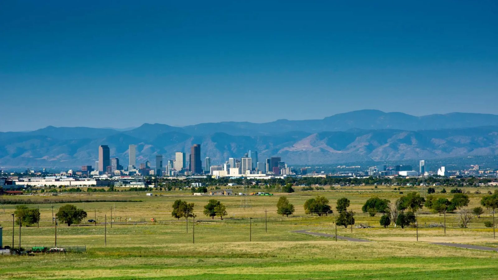 The Denver skyline and Front Range seen across open prairie from Commerce City