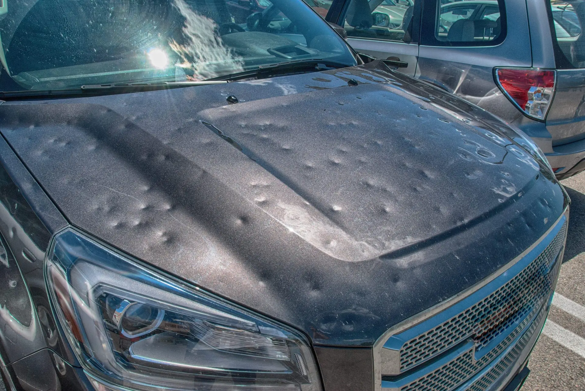 Hail damaged vehicle with dents across hood for paintless dent repair insurance claim in Denver Colorado