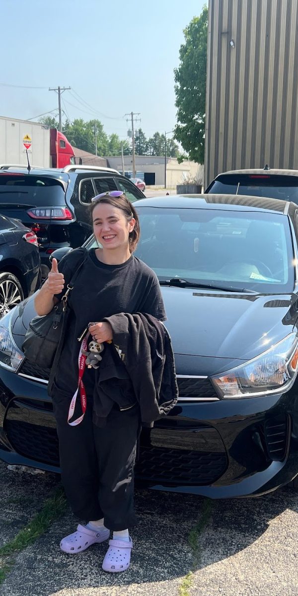 Happy Colorado Dent Solutions customer giving a thumbs up beside her repaired hail-damaged car