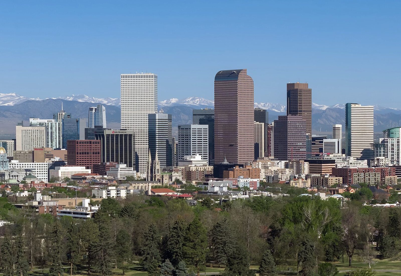 The downtown Denver, Colorado skyline with the snow-capped Rocky Mountains rising behind it