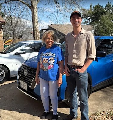 Colorado Dent Solutions customer standing with Alec beside their repaired blue vehicle