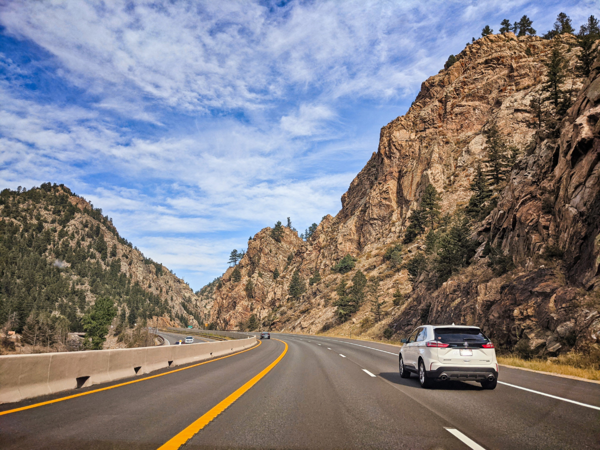 Vehicle driving on a Colorado mountain interstate through a rocky canyon on its way to the Denver shop